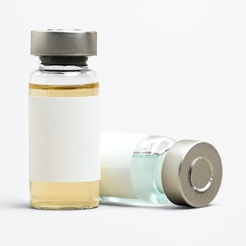 Blank vaccine label on injection glass bottles with colored liquid