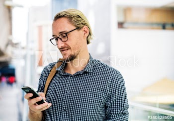 Blond man texting on his phone