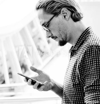 Blond man texting on his phone