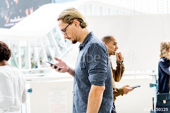 Blond man texting on his phone