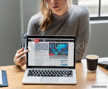 Blond woman pointing at a laptop screen