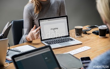 Blond woman pointing at a laptop screen