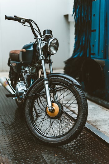Blue and Brown Cafe Racer Parked Beside Blue Building
