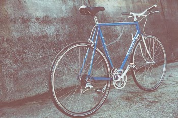 blue and gray rigid bicycle parked beside wall