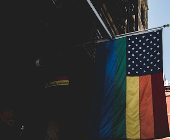 Blue and Multicolored Flag Hanging on Bulding