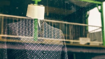 blue and purple plaid button-up shirt on dress form displayed near glass window
