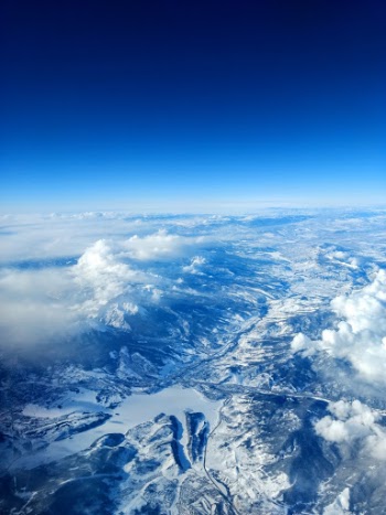 Blue and white aerial view of the snow-covered Rocky Mountains