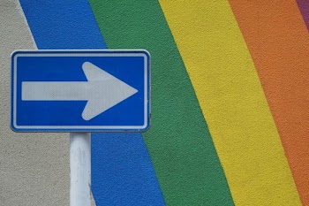 blue and white arrow signage near multicolored wall