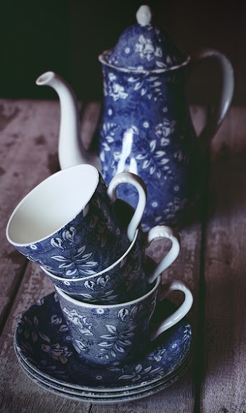 Blue and White Floral Ceramic Teacup and Teapot on Brown Wooden Table