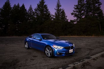 blue BMW coupe on brown asphalt road