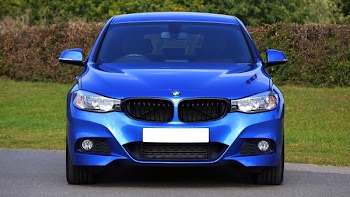 Blue Bmw Sedan Near Green Lawn Grass