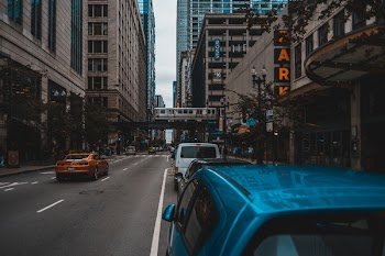 Blue Car on Concrete Road Near Concrete Buildings