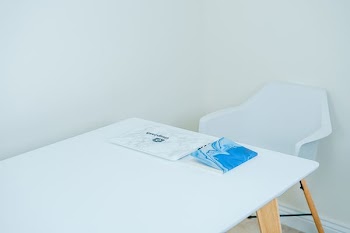 blue covered book on white table with armchair in front