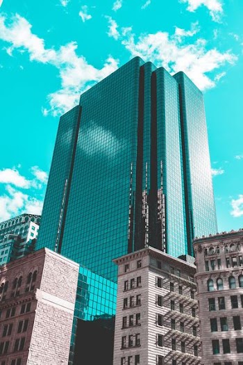 blue curtain wall building under teal skies