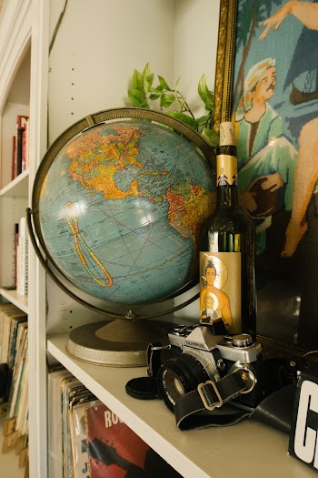 Blue Desk Globe Near Brown Bottle on Shelf