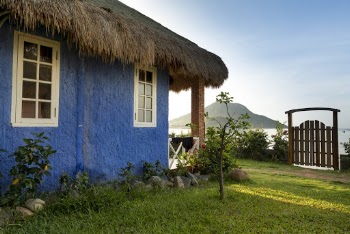 Blue Painted House With Hay Roofing