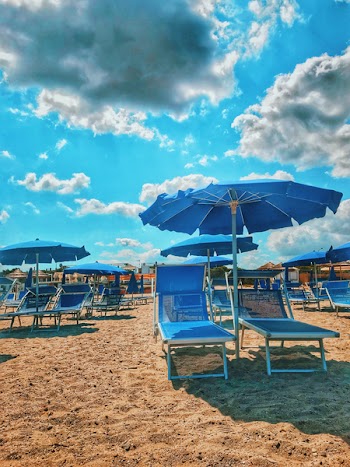 Blue Parasols And Sun Loungers On Sand