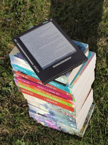 Blue Pink Gray and Green Labeled Hardbound Book Pile on Green Grass during Daytime