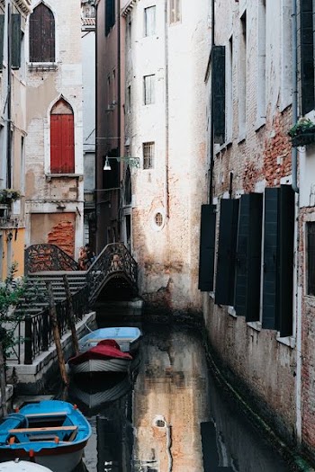 blue plastic boats in body of water beside concrete buildings