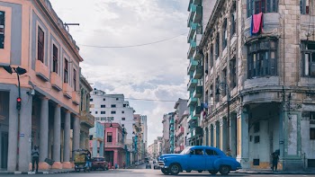 Blue Sedan on Road Between Buildings