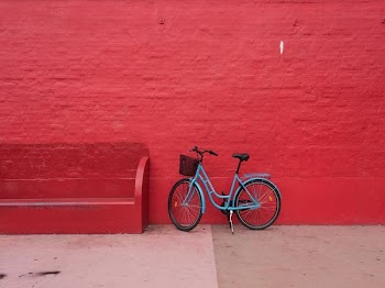 blue step-through bicycle park beside of red bench
