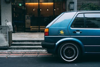 blue vehicle parked outside storefront at daytime