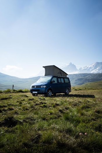 blue Volkswagen Transporter van on green grass field