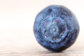 Blueberry Placed on Brown Surface