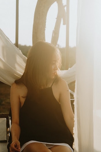 Blurry Photo of Woman Wearing Black Strap Dress