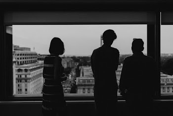 Blurry silhouette of Three people Looking Through the window  in the black and white night  