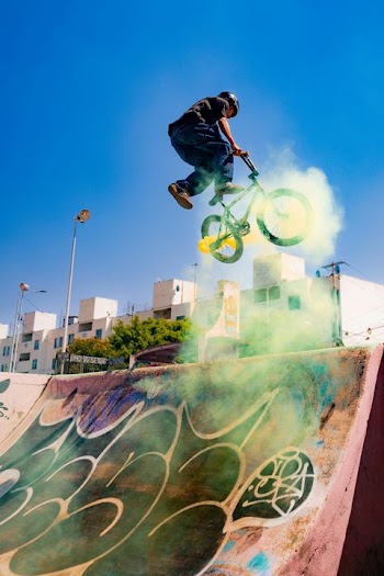 BMX Rider Performing Trick with Colorful Smoke Bombs