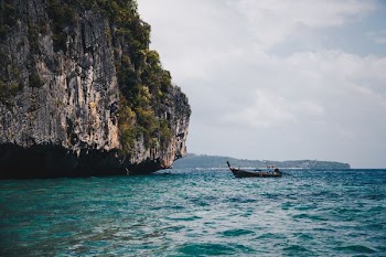 Boat Beside Cave on Body of Water