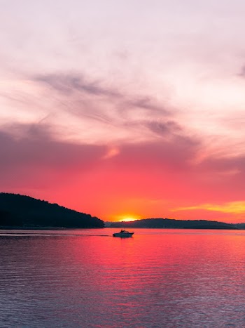 Boat in Middle of Body of Water during Sunset