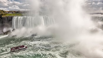 Boat Near Waterfalls during Daytime