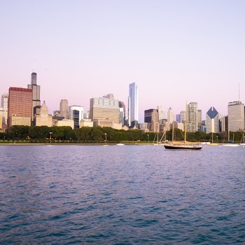 Boat on Body of Water in Front of Cityscape