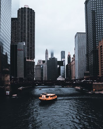 Boat on Body of Water Near Buildings of the City