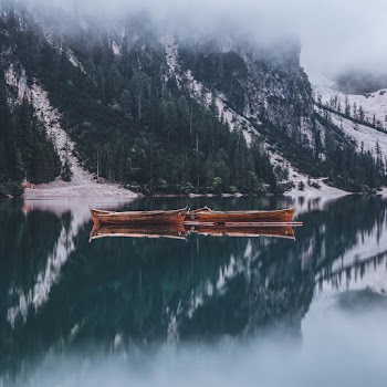 Boats at Calm Body of Water by Mountain Slip