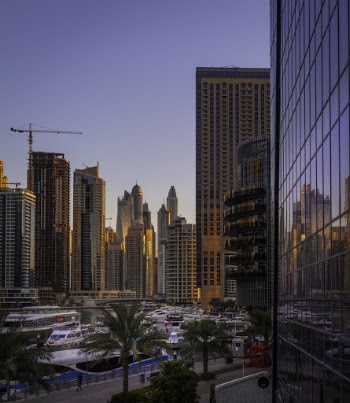 Boats Near High-rise Buildings Under Blue Skies