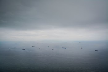 boats on calm sea under dim sky