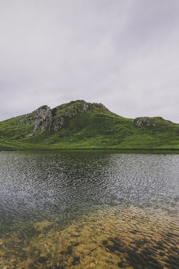Body of Water Across Green Hill