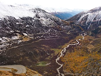 body of water between snow-capped mountains at daytime