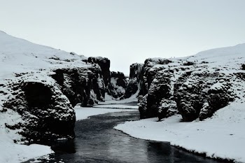body of water between snowy mountains