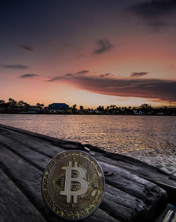 Body of Water during Dawn With Bitcoin Logo Text Overlay