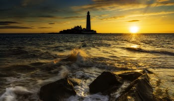 Body of Water Near Lighthouse during Golden Hour