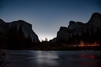 body of water near open field background of mountain