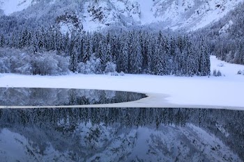 body of water near snow coated land