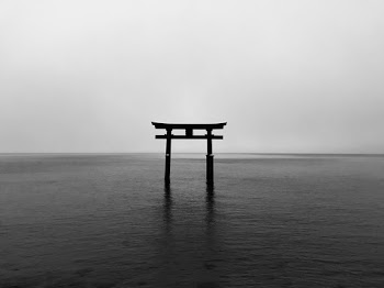 Body of Water Surrounded by Foggy Sky