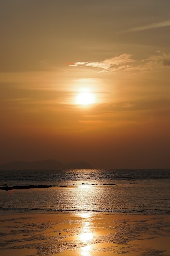 Body of Water Under Brown Sky at Golden Hour