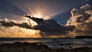 Body of Water Under Clouds With Sun Rays