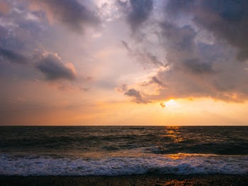 Body of Water Under Gray and Blue Skies